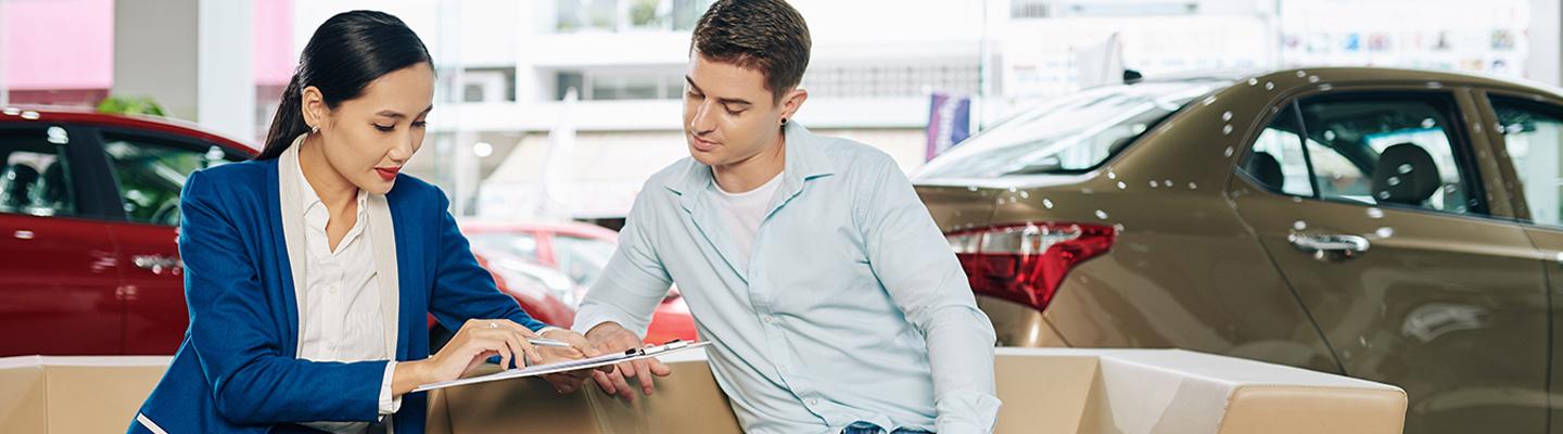 Woman and man discussing car in dealership showroom