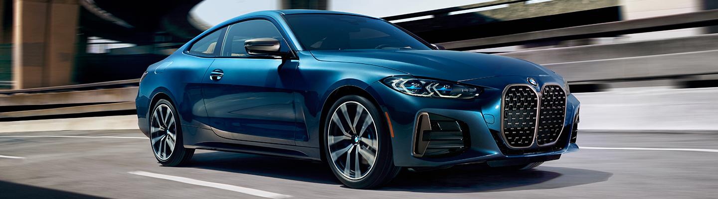 Side view of a blue 2020 BMW 4 Series in motion
