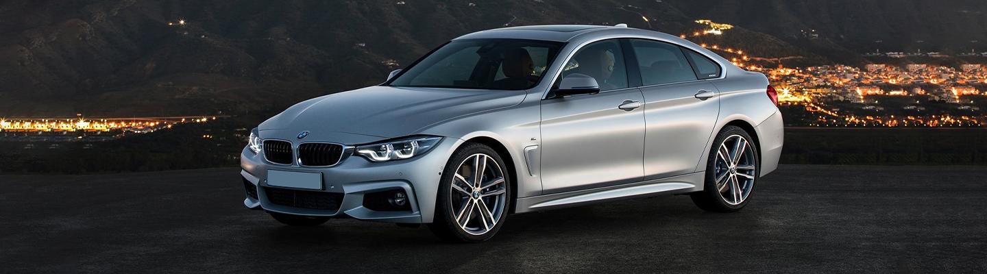 Silver BMW parked at scenic overlook town in lights