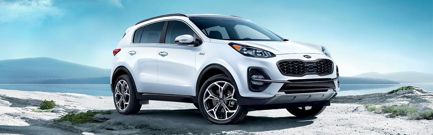 White Kia parked near the ocean 