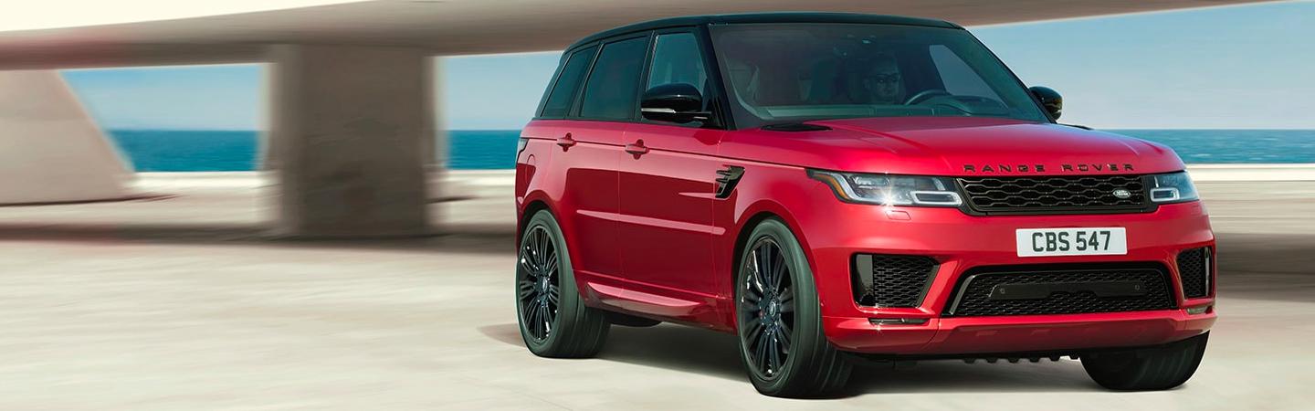 Red Range Rover driving by the ocean