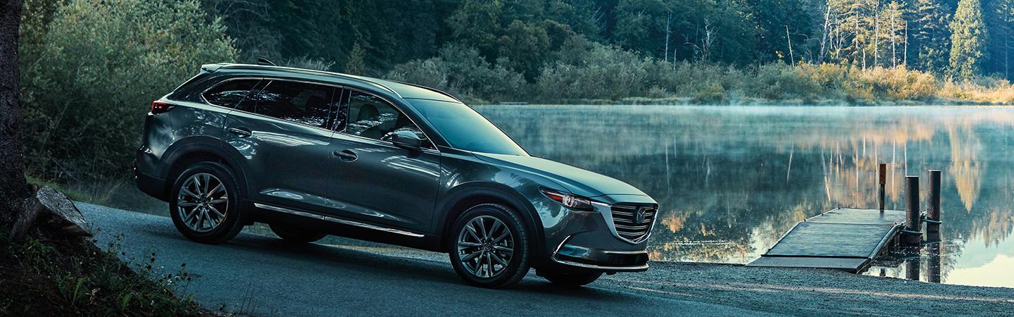 Side view of the 2020 Mazda CX-9 driving next to a lake