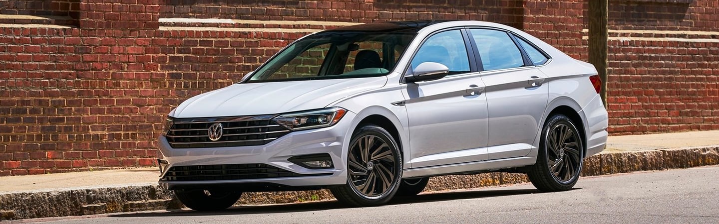White Jetta parked near a building 