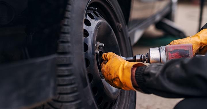 Technician taking tire off car