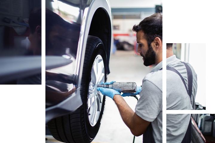 Technician taking tire off car on lift
