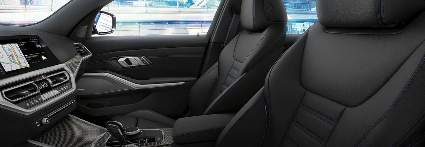 Side view of the front seats and infotainment system in a BMW 3 Series.