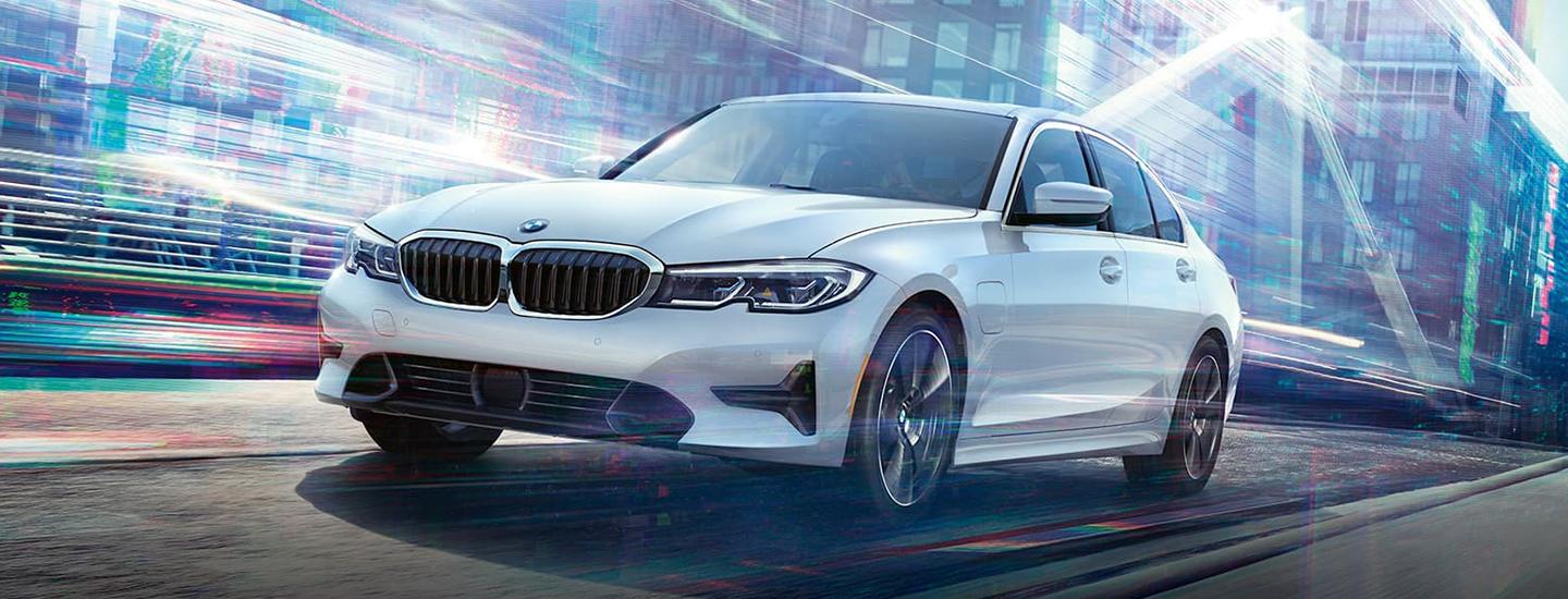 White BMW 3 Series driving along the road.