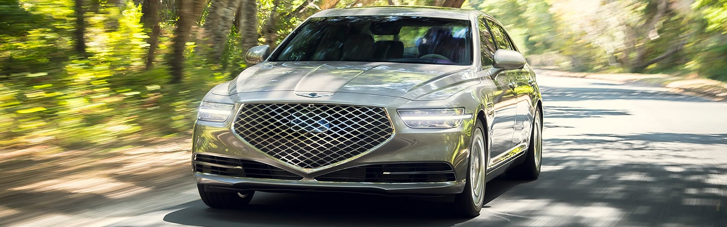 Silver G90 driving near woods