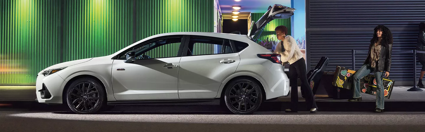 2026 Subaru Impreza with a person loading the trunk with boxes