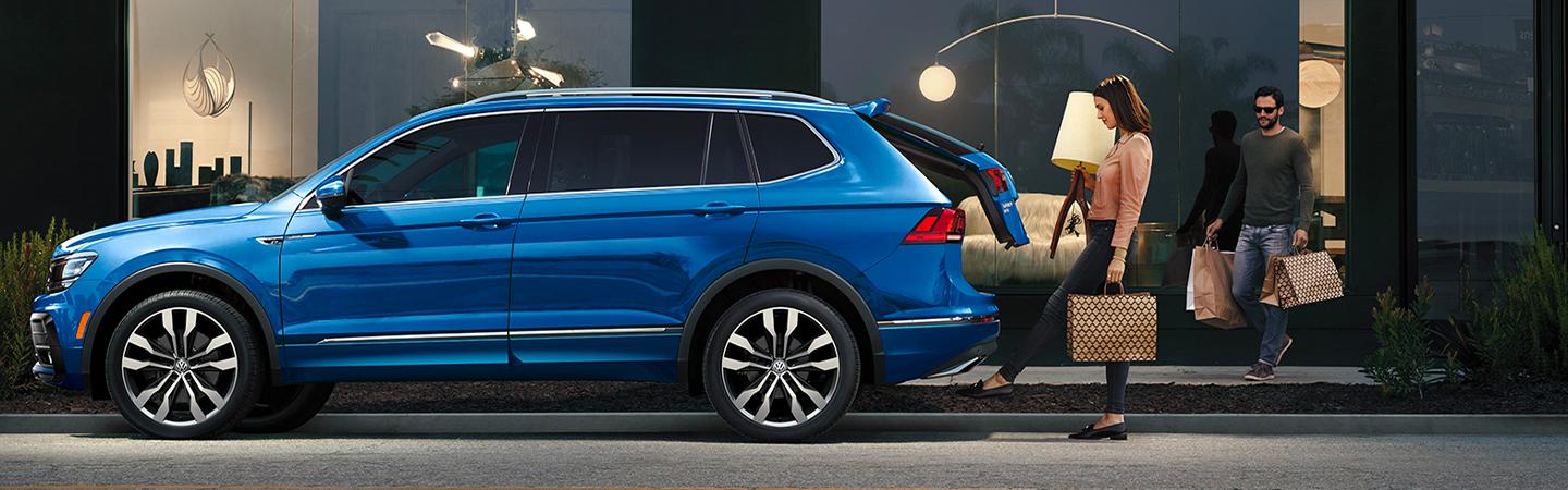 Woman loading cargo into a blue 2020 Volkswagen Tiguan