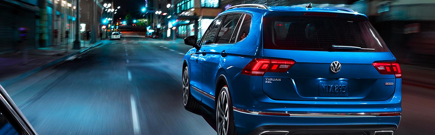 Rearview of a blue Volkswagen Tiguan driving in the city