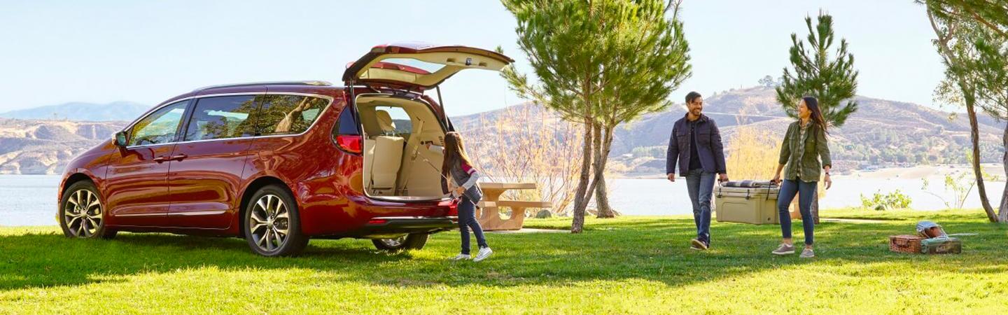 Red Pacifica parked in a park with hatch open