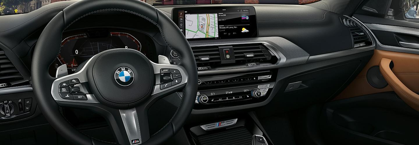 Close-up of a BMW X3 steering wheel and infotainment system.