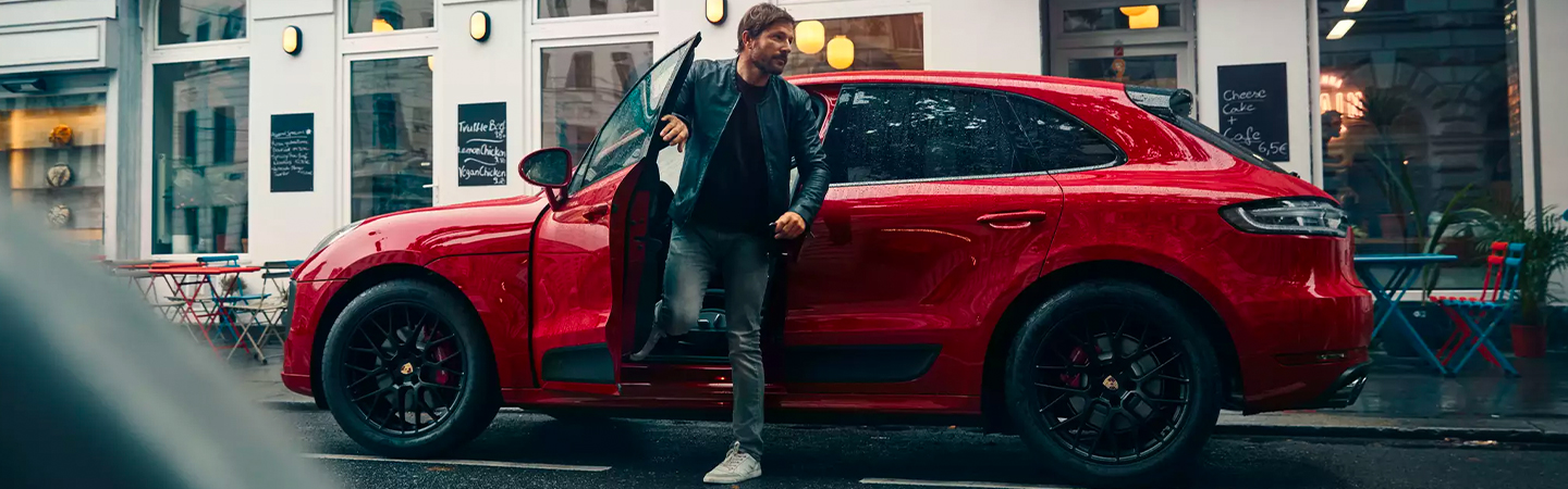 Man getting out of a red 2020 Porsche Macan 