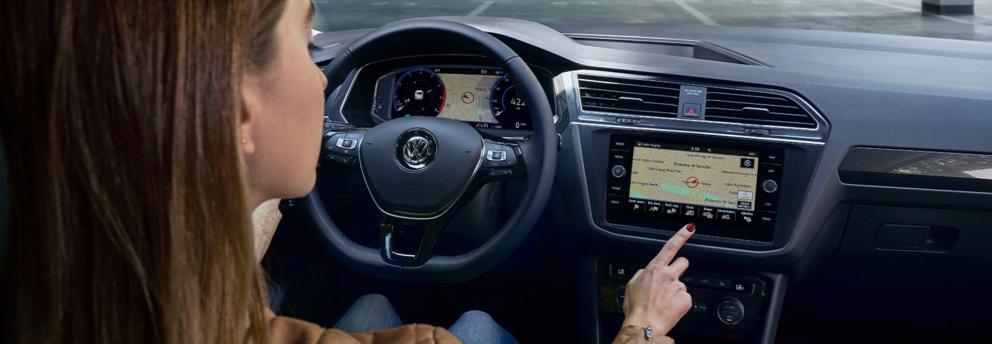Steering wheel and woman controlling the infotainment in a Tiguan