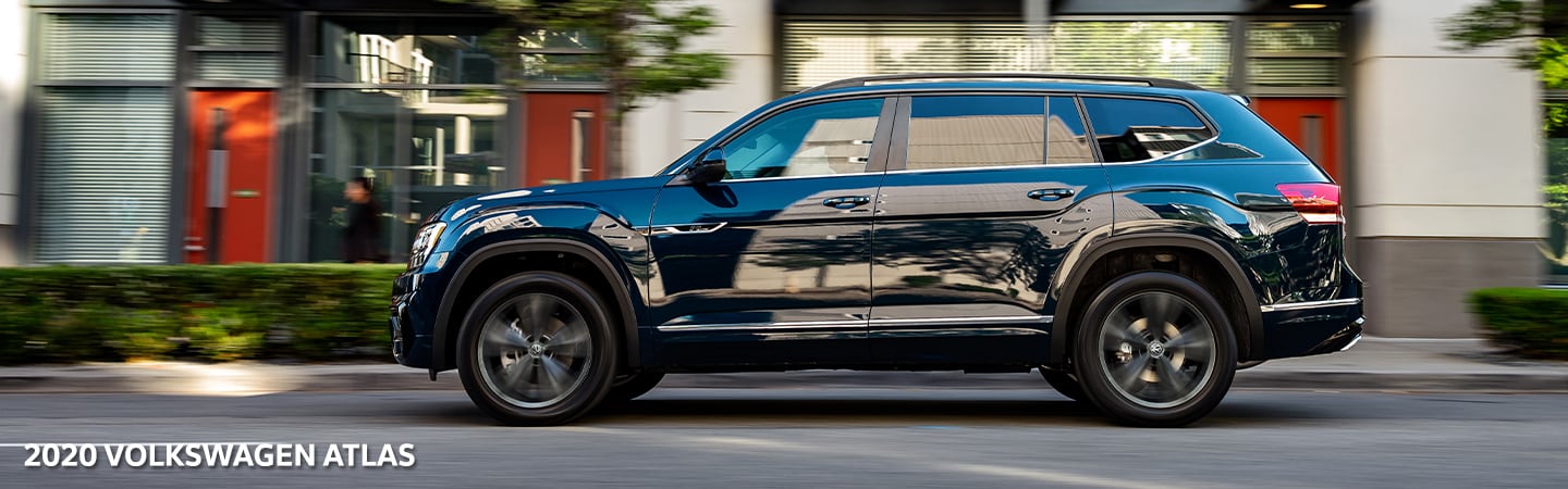 Woman drinking coffee next to the 2020 Volkswagen Atlas