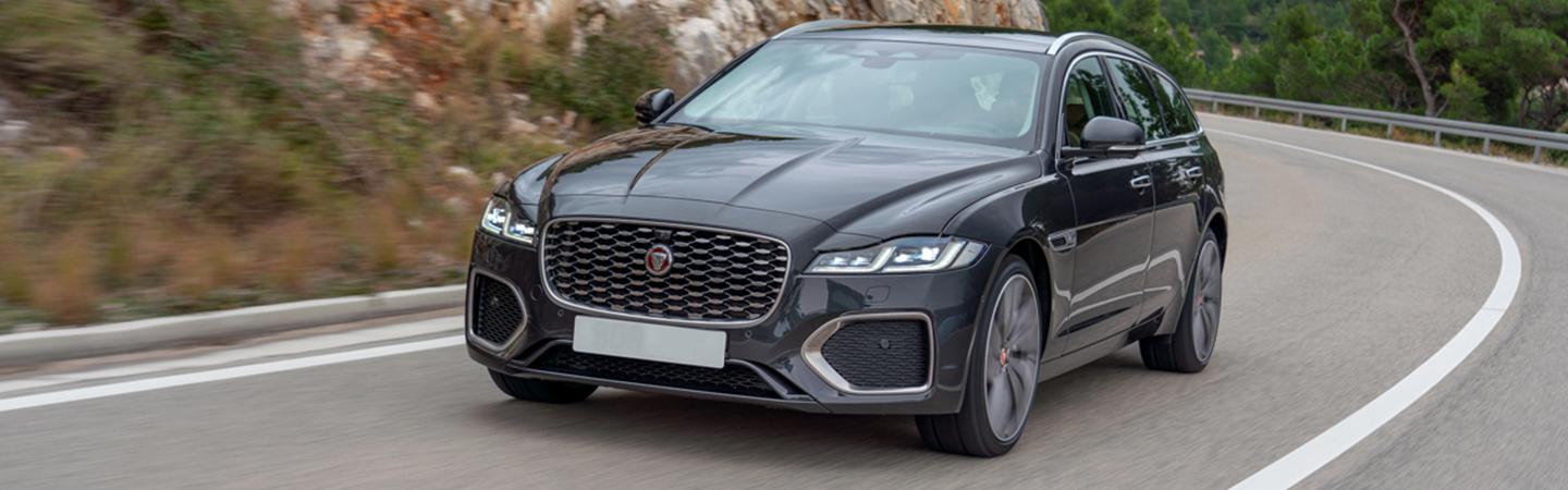 Front view of a black Jaguar FX driving along the mountainside