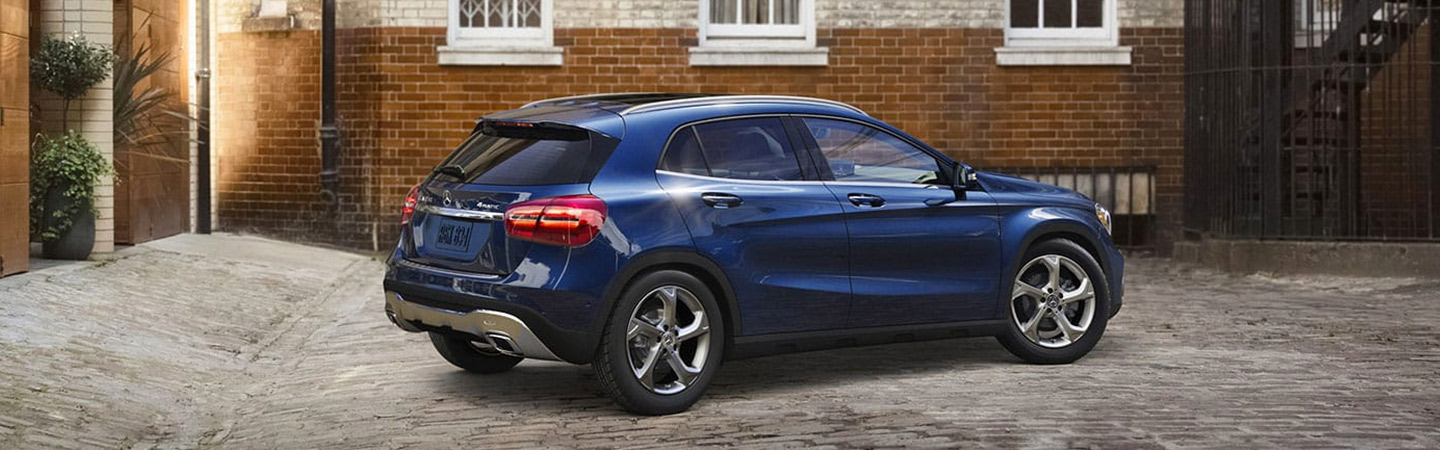 Blue Mercedes-Benz SUV parked behind a building