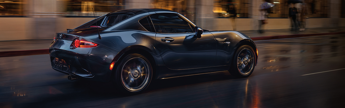 Side view of a blue 2020 Mazda MX-5 Miata in motion