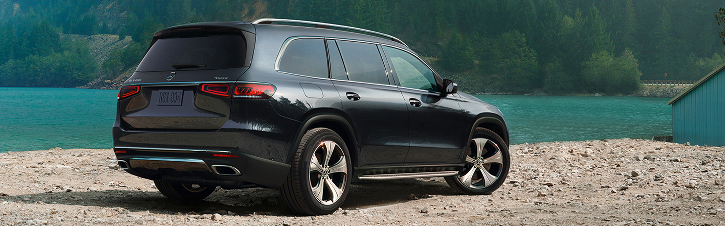 Rear angle view of gray GLS parked by a lake