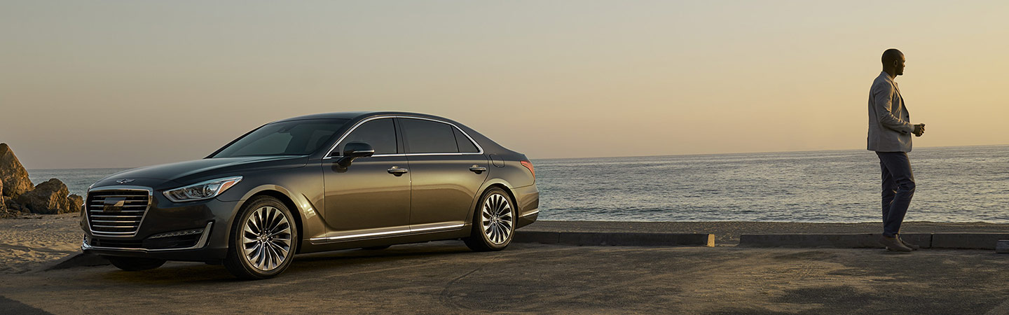 Driver-side view of the Genesis G90 parked by the ocean