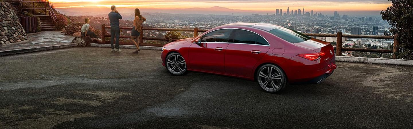 Side view of red CLA parked next to a sunset