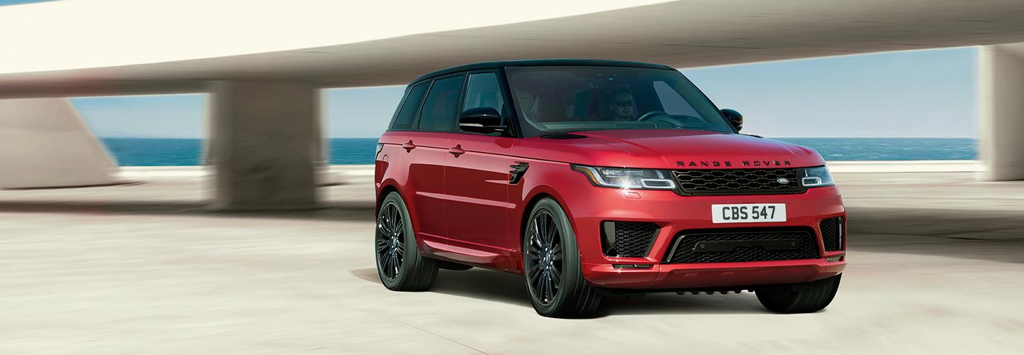 Red Land Rover Range Rover near the ocean