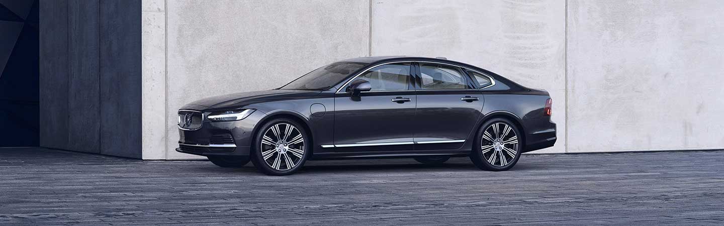 Side view of S90 parked next to a building
