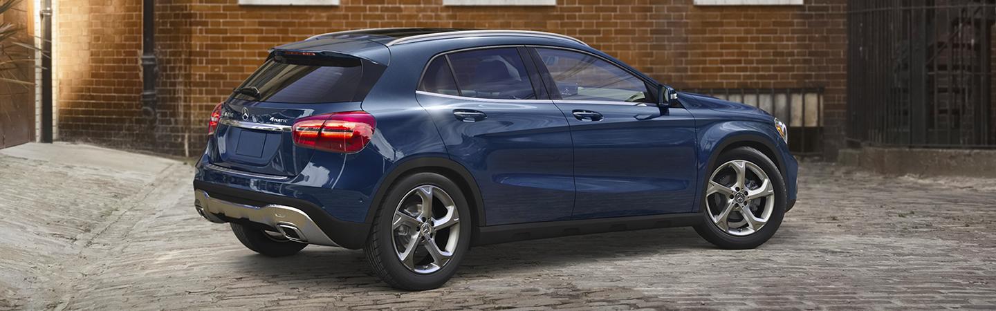 Blue GLA 250 parked by a brick wall