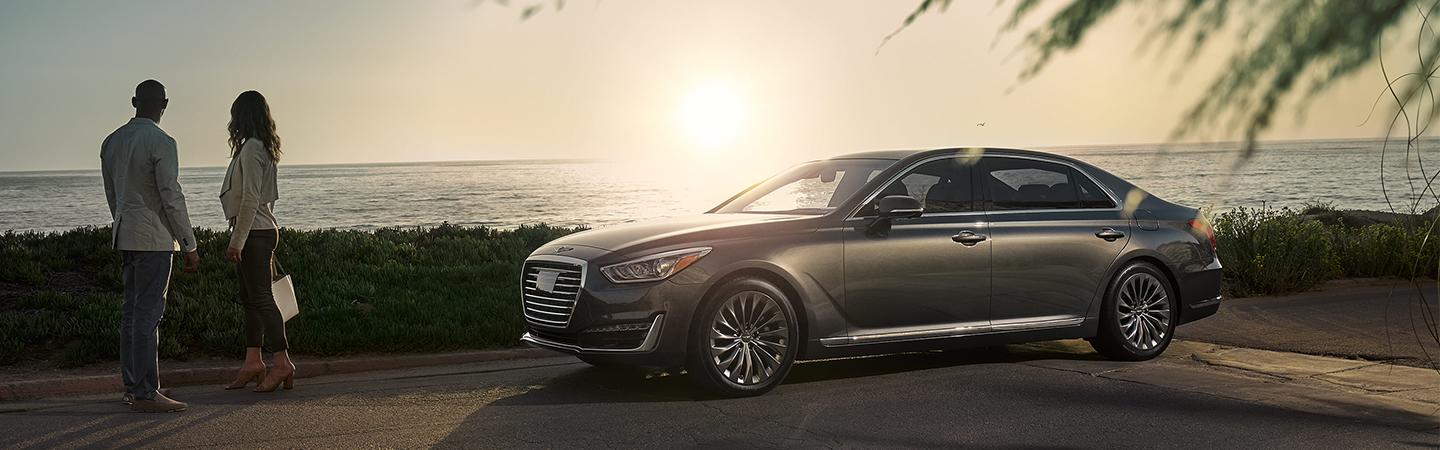 Silver G90 parked next to the beach with a couple standing by