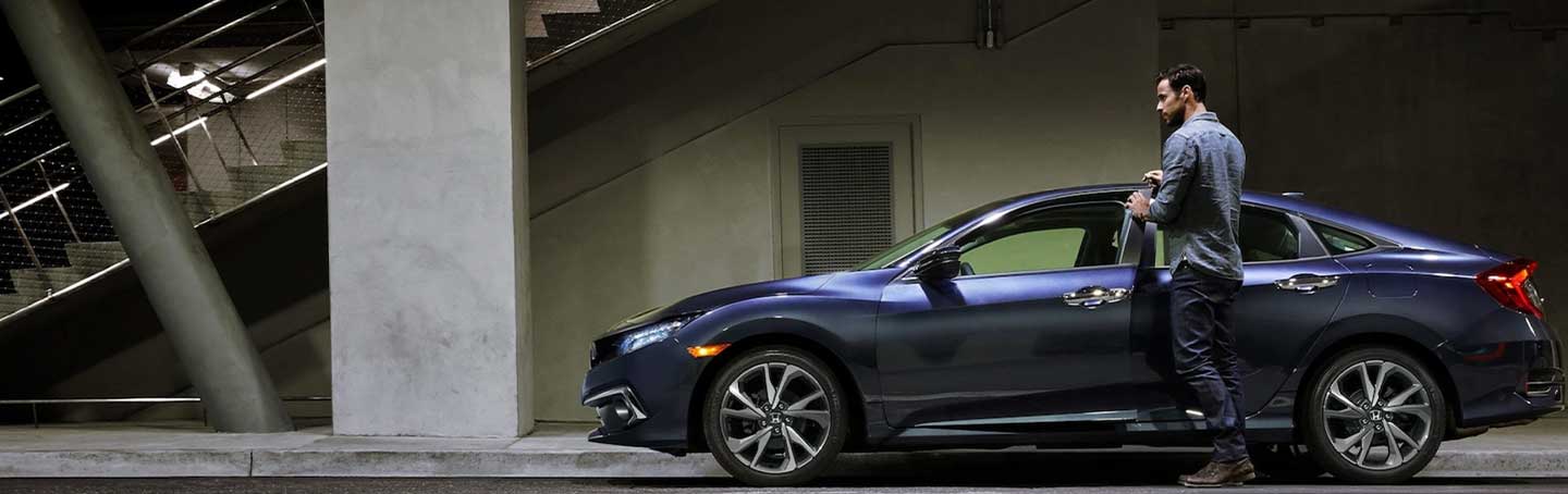 Driver getting into a parked blue Honda Civic