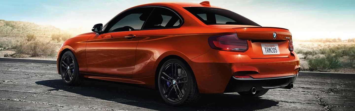 Rear view of a red BMW 2 Series parked.