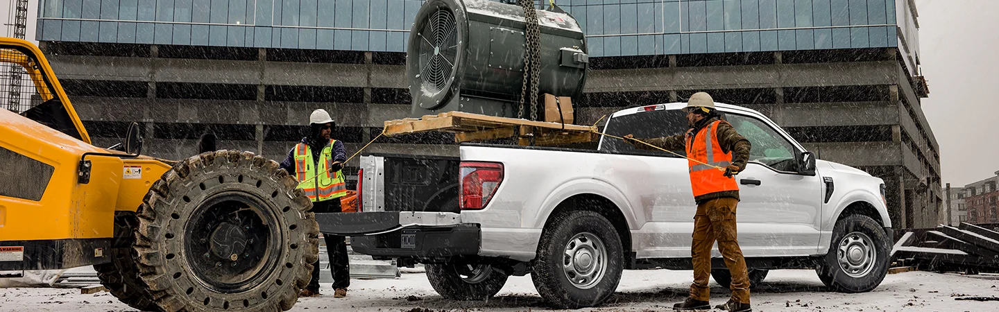 white 2025 Ford F-150 loading with poclain