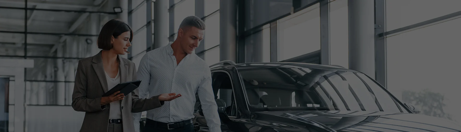 man and woman looking at a car