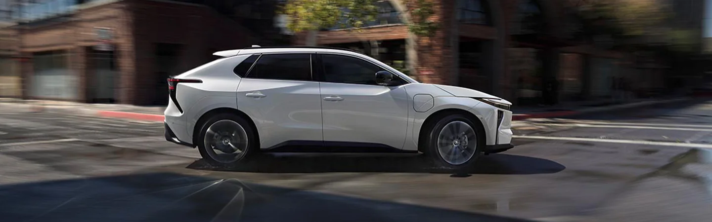 white 2026 Toyota RAV4 Limited PHEV taking corner incity