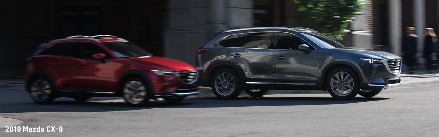 Two 2019 Mazda CX-9 vehicles in motion outside of Werner Mazda
