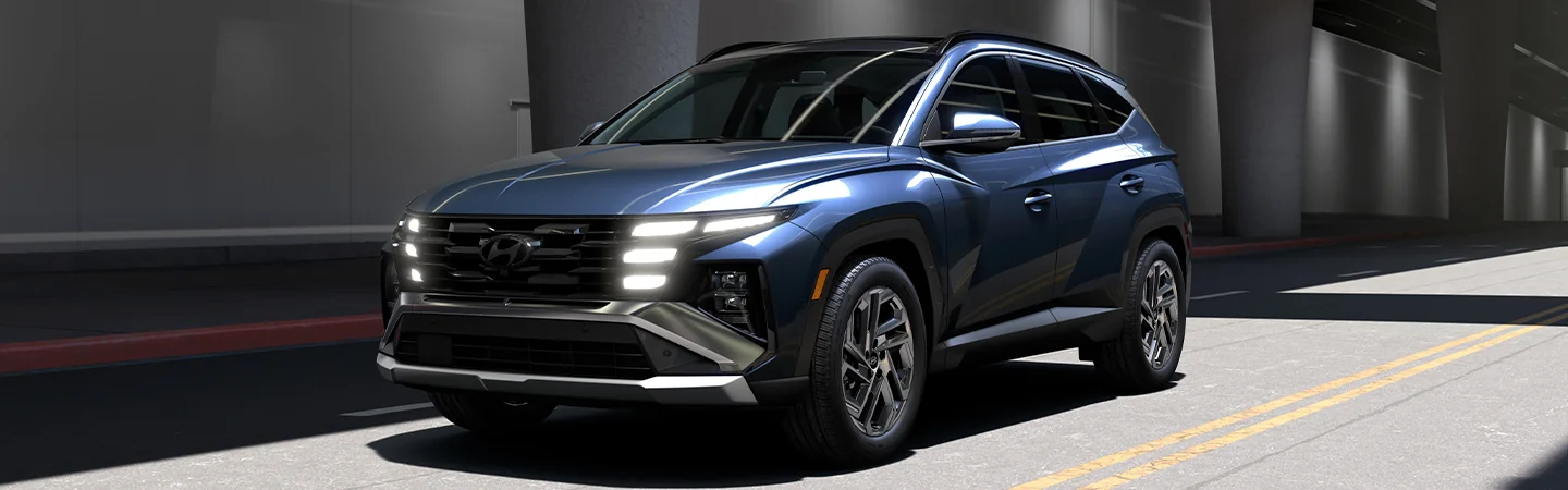 Blue 2025 Hyundai Tucson driving on the highway