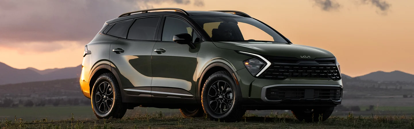 The green 2025 Kia Sportage X-Pro Prestige is parked in an open area