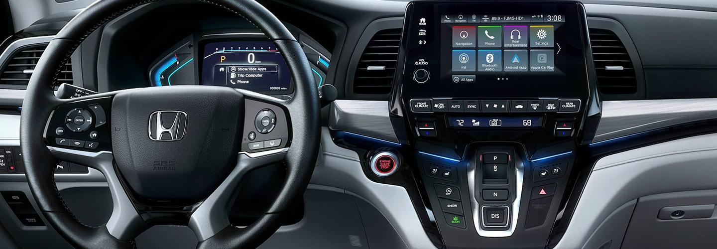 Close-up of the steering wheel and infotainment center of a Honda Odyssey.