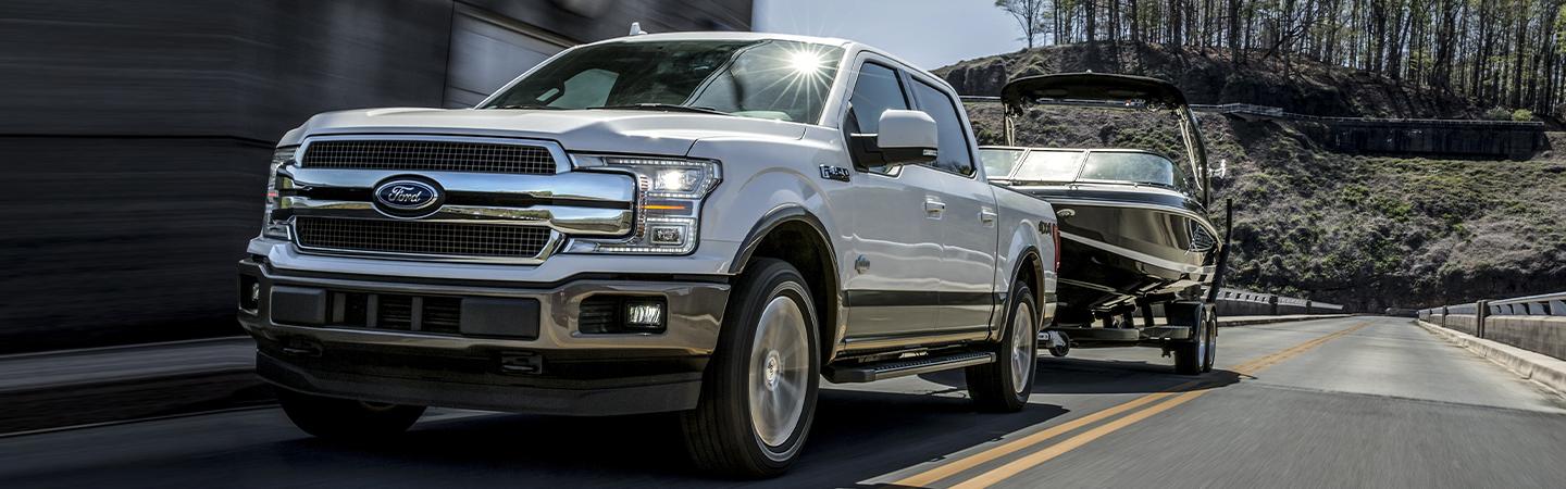 White 2020 Ford F-150 towing small boat