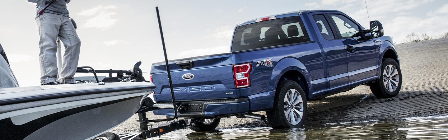 Blue 2020 Ford F-150 towing boat out of water