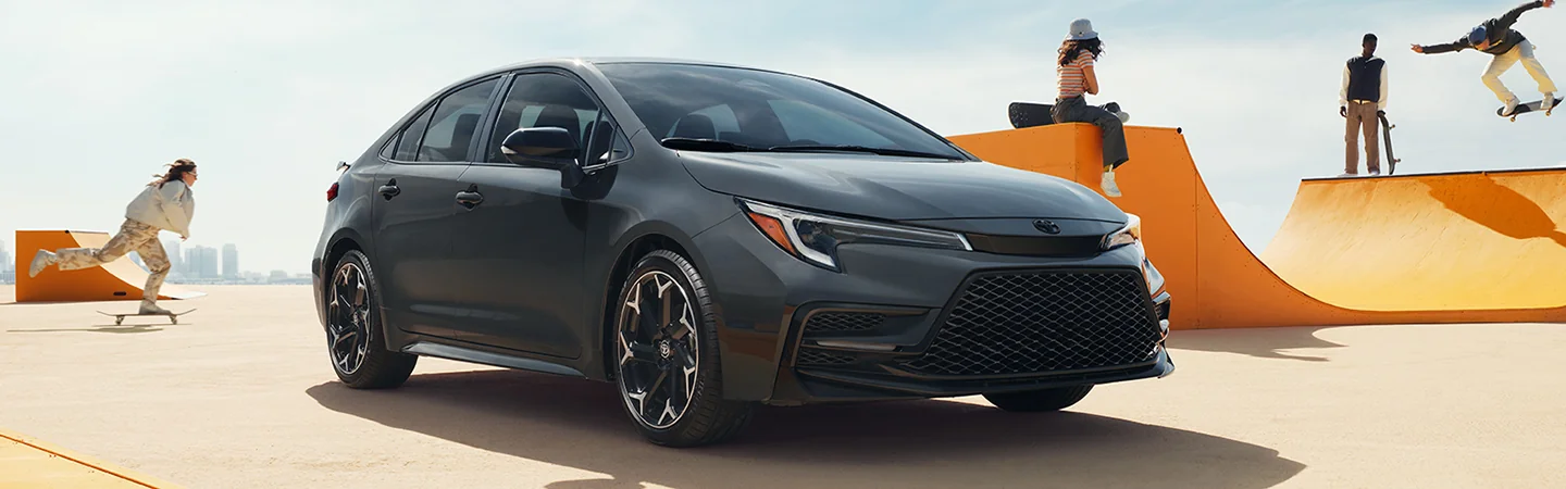 Grey 2025 Toyota Corolla parked on the ground with men and women playing