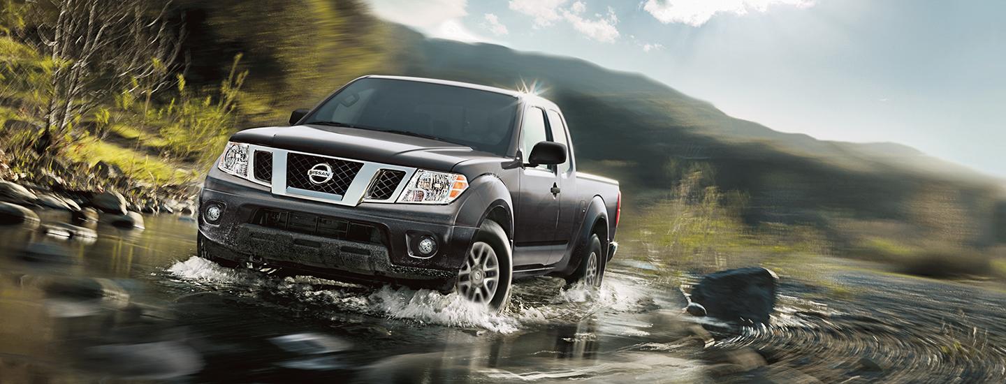 Grey Nissan Frontier fording a creek.