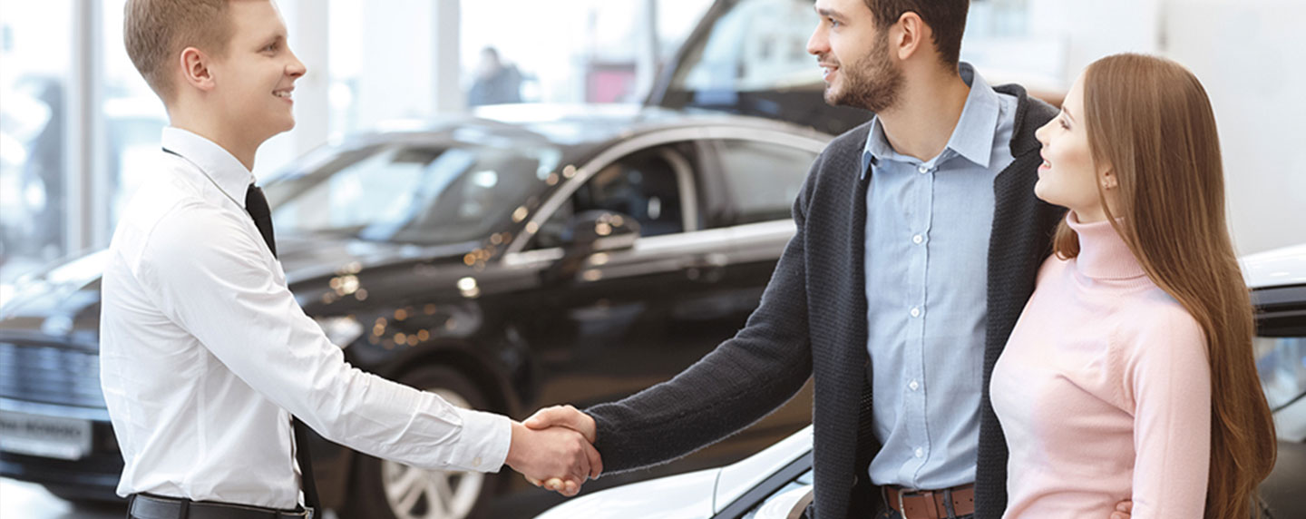 Man and woman talking to a financing professional at our dealership.