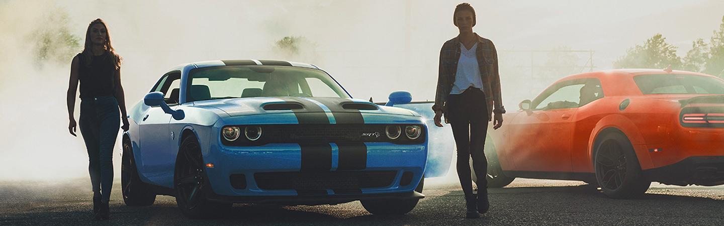 Two Dodge Challenger models parked sidy by side