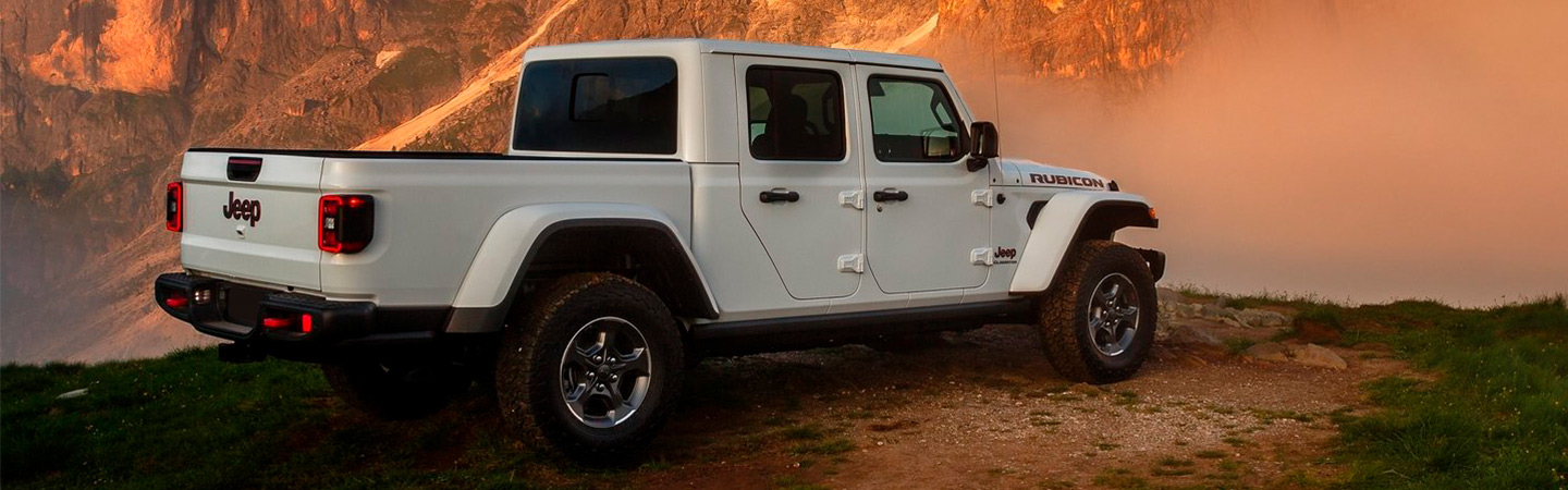 White Jeep Gladiator parked near mountains