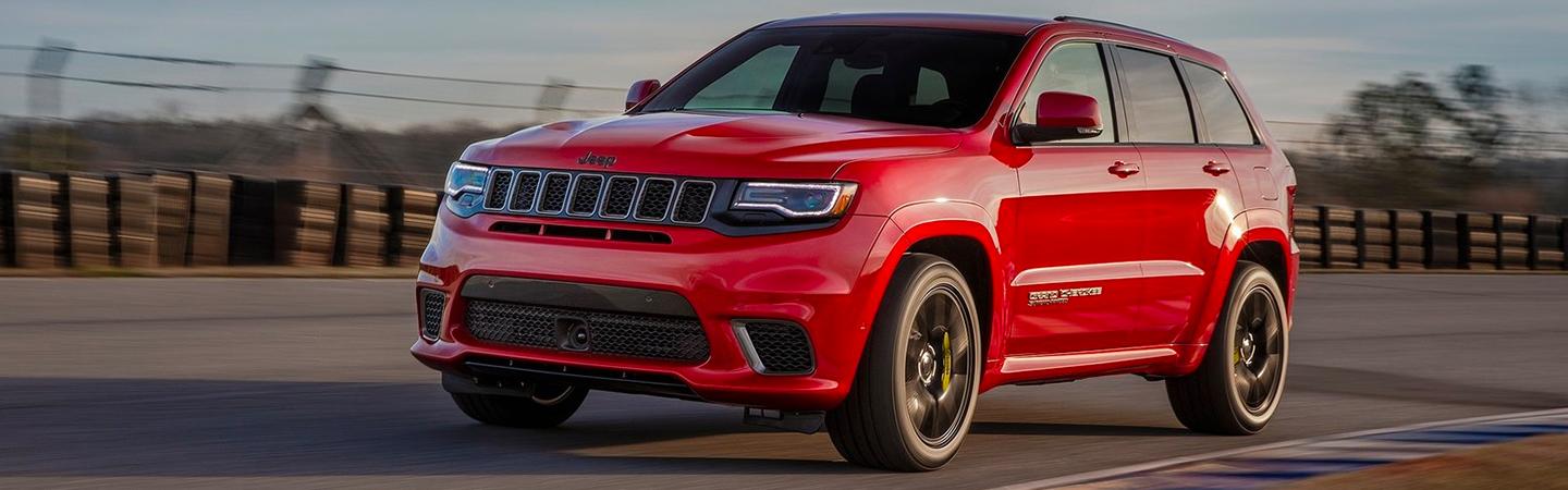 Red 2020 Jeep Grand Cherokee driving on aroad