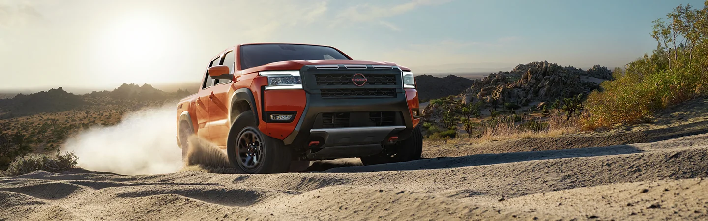 2025 Nissan Frontier SL driving on a dirt road