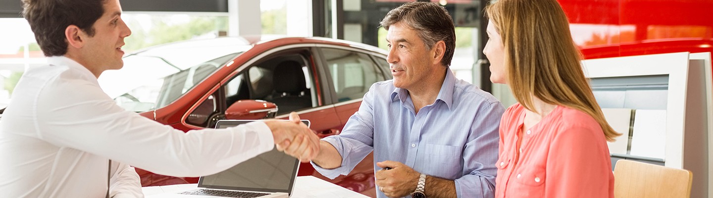 A man shaking salesman hand at the dealership