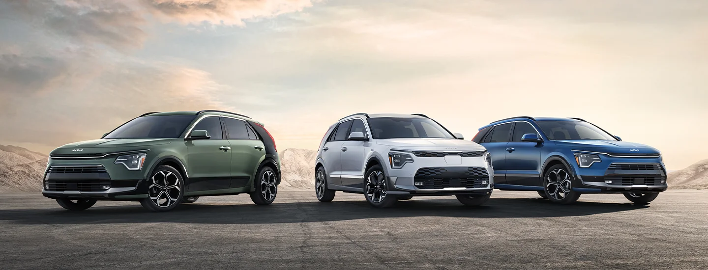 Side by side view of Kia Niro Models parked in front of mountains